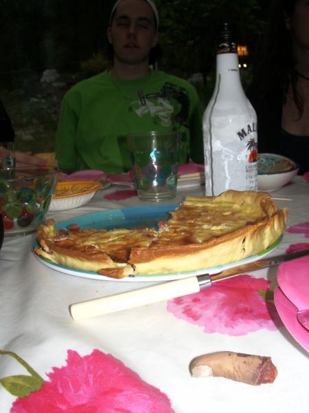 au fond, on peut aperçevoir FloW, au second plan : une quiche, et au premier plan : un doigt.